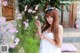 A woman in a white dress holding a bunch of flowers.