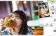 A woman eating a hamburger in a restaurant. 