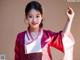 A woman in a red and white kimono posing for a picture.