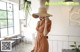 a woman wearing a brown dress and a straw hat