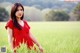 A woman in a red dress standing in a field.