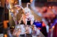 A woman sitting at a table with wine glasses.